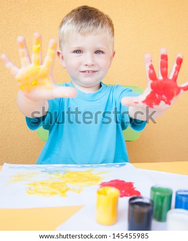 Portrait of a little boy enjoying his painting