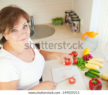 Older woman in kitchen preparing healthy food