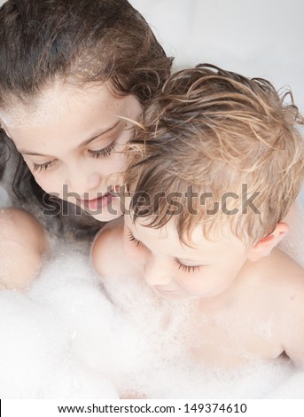 Brother and sister taking a bubble bath .