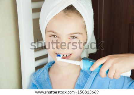 Little girl brushing teeth in bath