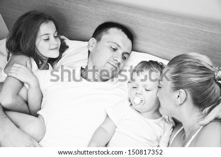 Happy young family having fun in bedroom
