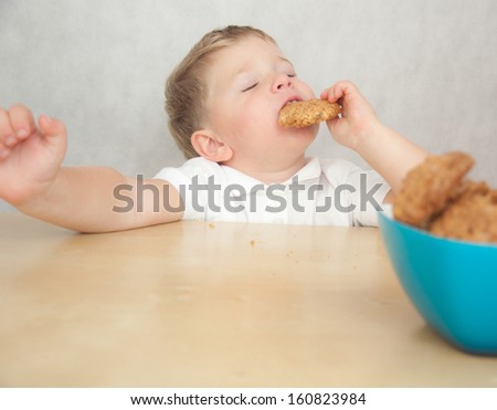 Cute little boy eating cookies