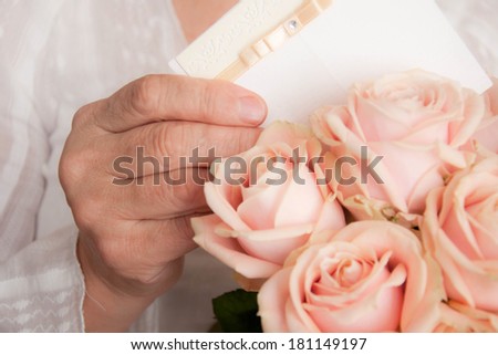 Elderly woman holding bouquet of roses. Mother\'s day background