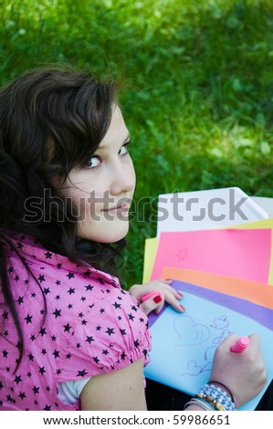beautiful young teen draws in the park