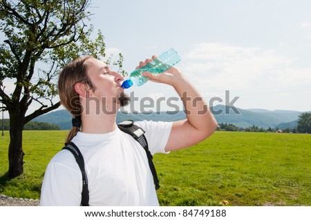 man drinking water in mountains