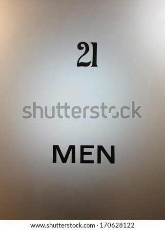 Old glass door to a men\'s washroom