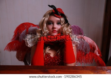 A beautiful young blonde lady is posing in an old pub and restaurant. She is wearing various Broadway performer outfits.