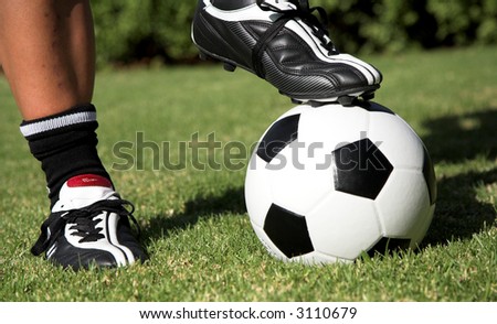 Man standing with one soccer boot on top of the soccer ball and another foot next to the football. Soccer worldcup promotion