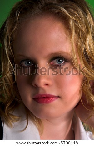 Beautiful blonde with curly locks looking at camera, close-up and crop of face