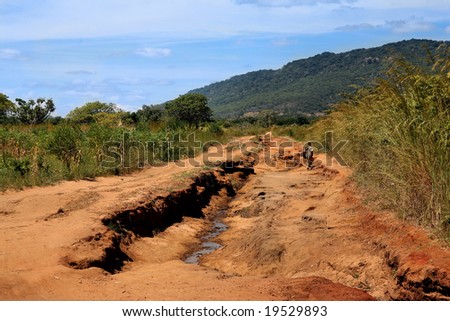 a man walking on a road to nowhere in Africa