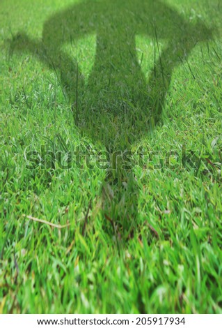 Shadow of a man figure meditating on the grass