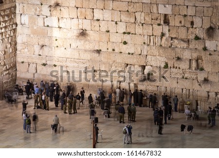 Jewish men praying on Western Wall at night in Jerusalem, Israel.