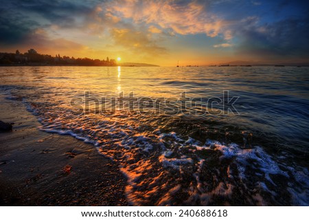 Sunlight breaking at dawn over a sandy shore