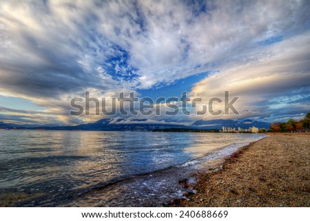 Blue skies on a sandy riverside with distant cityscape