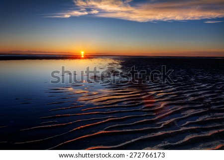 Magnificent ocean ripples on water surface at dawn with distant cliffs