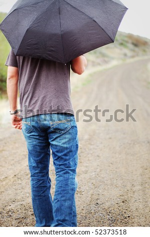 Man Walking with Umbrella in the Rain down Country Road