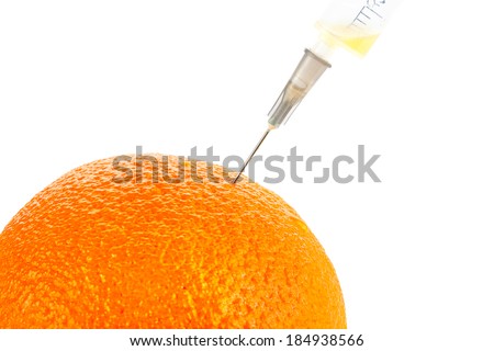Fresh orange with a syringe. Concept for genetically modified food and cosmetic medicine