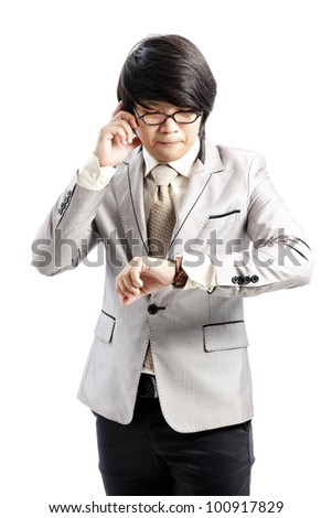 businessman has a look at his watch while making a phone call