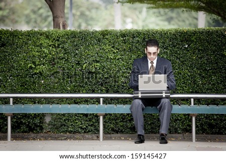businessman working laptop and waiting for the bus,Time is money.