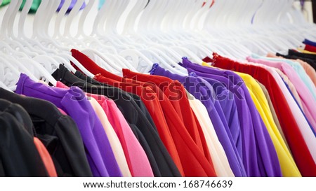 Choice of fashion clothes of different colors on hangers