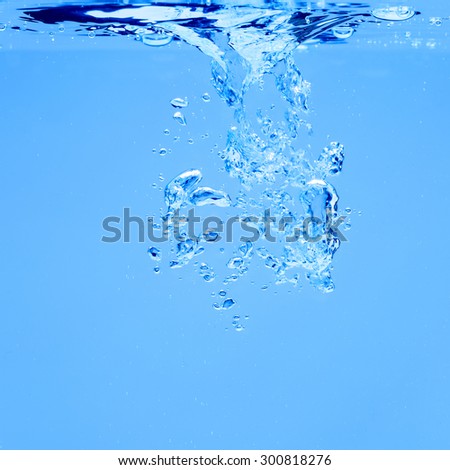 Closeup of blue bubbles underwater on blue background