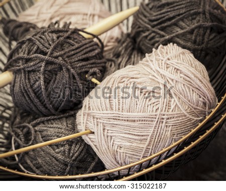 Vintage knitting needles and yarn inside old wire basket, still life photo with soft focus