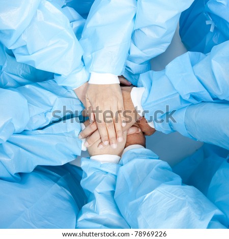 Small group of doctor team joining hands, bird\'s eyes angle view.