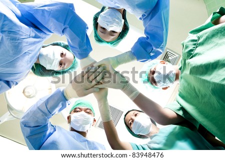 Small group of doctor team joining hands,ant\'s eyes angle view.