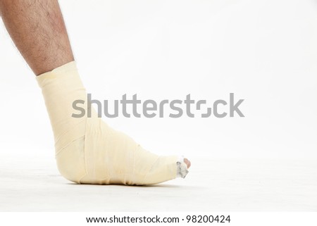 Ankle of male athlete being wrapped with white bandage