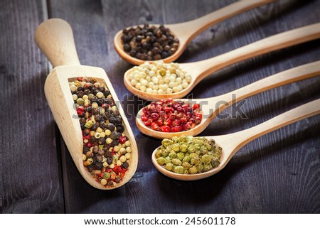 Mixed green, red, white and black peppercorns in a wooden spoon, shallow depth of field