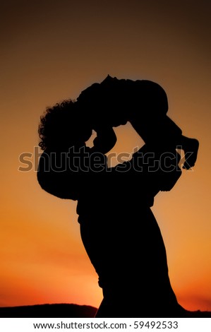 Silhouette of father and child on the beach   on beautiful summer sunset - family