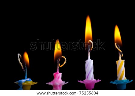 Birthday color candles with fire on black background