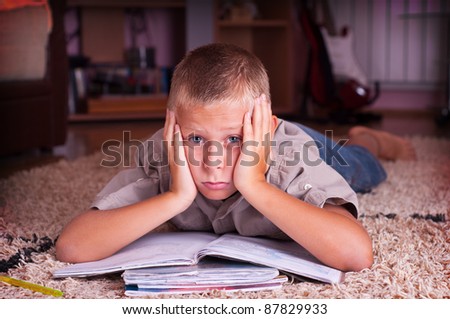 ten year old boy reading book, tired of learning process
