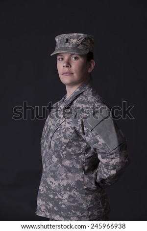 Military woman fold her arms, studio low key