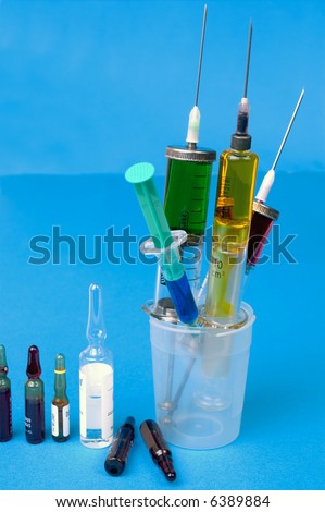 Syringes and ampoules on blue background