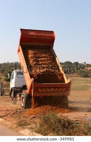 Truck dumping sand at building site