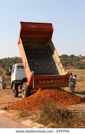 Truck dumping sand at building site