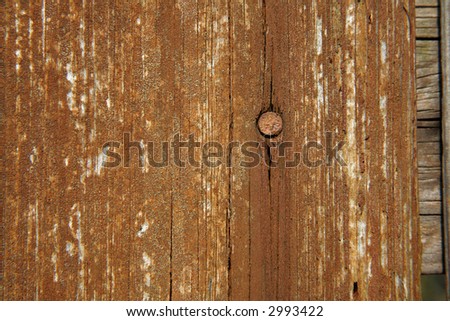 An old wooden board with nail, close up.