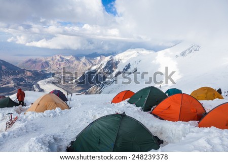 Mountain view from  Lenin peak camp 4. Climbers preparing for  summit attempt in their tents. Pamir mountains, Kyrgyzstan