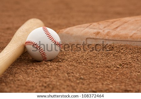 Baseball & Bat on the Infield Dirt near a base