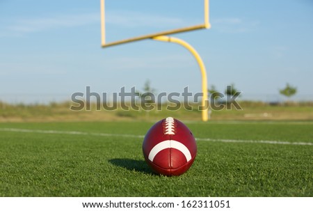 American Football with the goal posts or uprights in the background