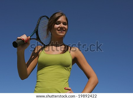 Happy brunette tennis woman holding her racket