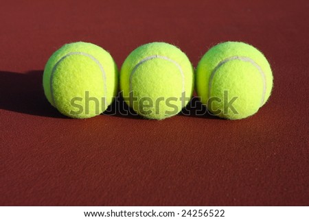 Three tennis balls on the court with room for copy
