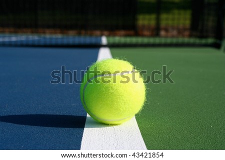 Tennis ball on the court with Net in background