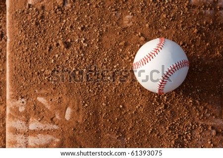 New baseball on a dirt covered base