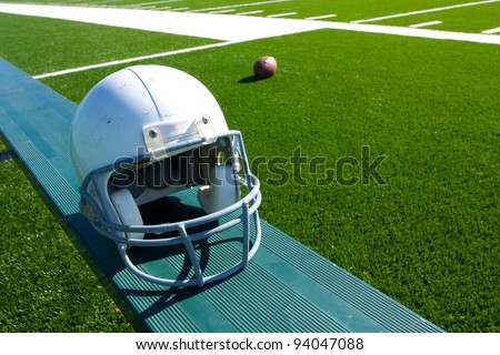 American Football Helmet on the Sideline Bench with field in the background