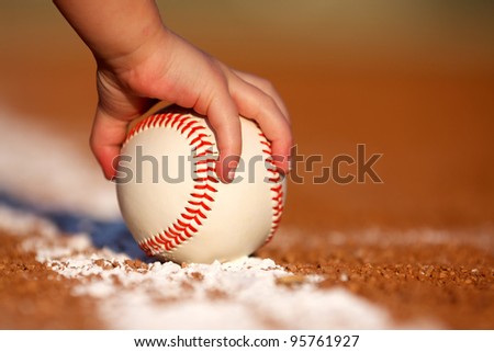 Child\'s hand grabbing a baseball