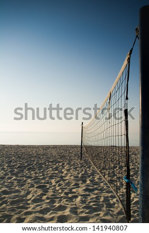 Vertical shot of empty beach volleyball field. Net is in first plane.