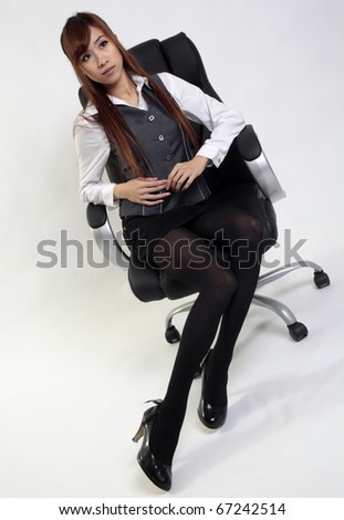Office lady poses on office chair.