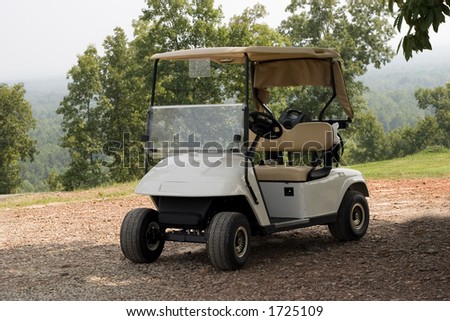 A single new golf cart standing in readiness at a mountain top golf course